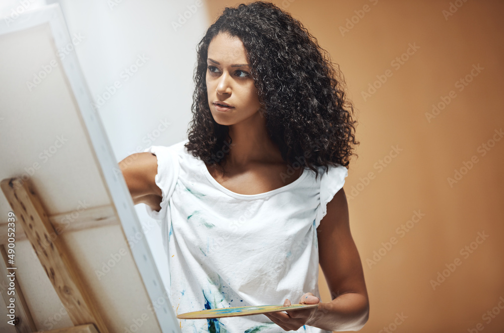 Life is a canvas. Paint your masterpiece. Shot of an attractive young woman painting on a canvas at 