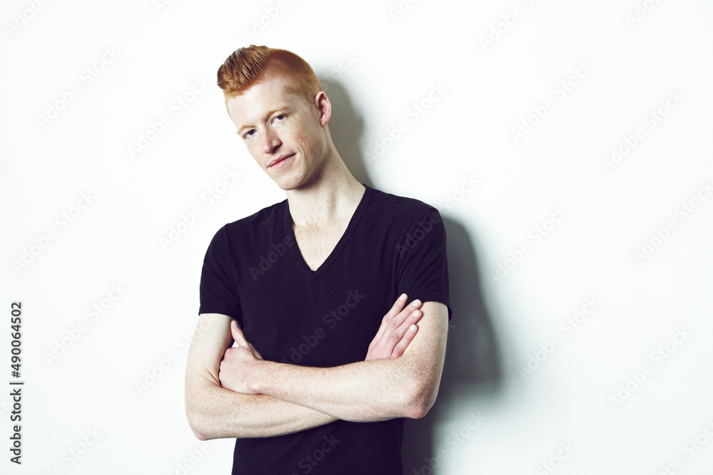 Im ready for my close up. A red haired male crossing his arms while looking at the camera against a 