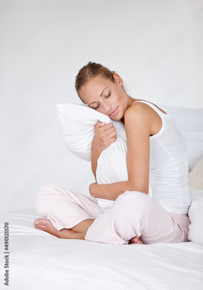 Im not getting out of bed today. A beautiful young woman hugging her pillow while on her bed.