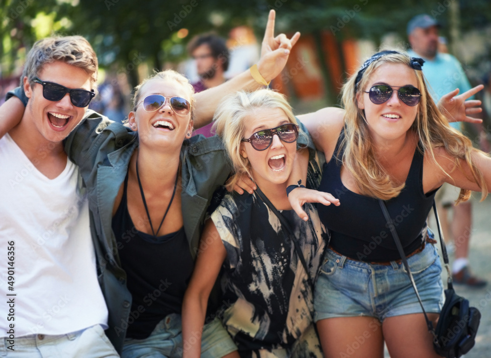 High on music and life. Four young friends rocking out to a band at a music festival.