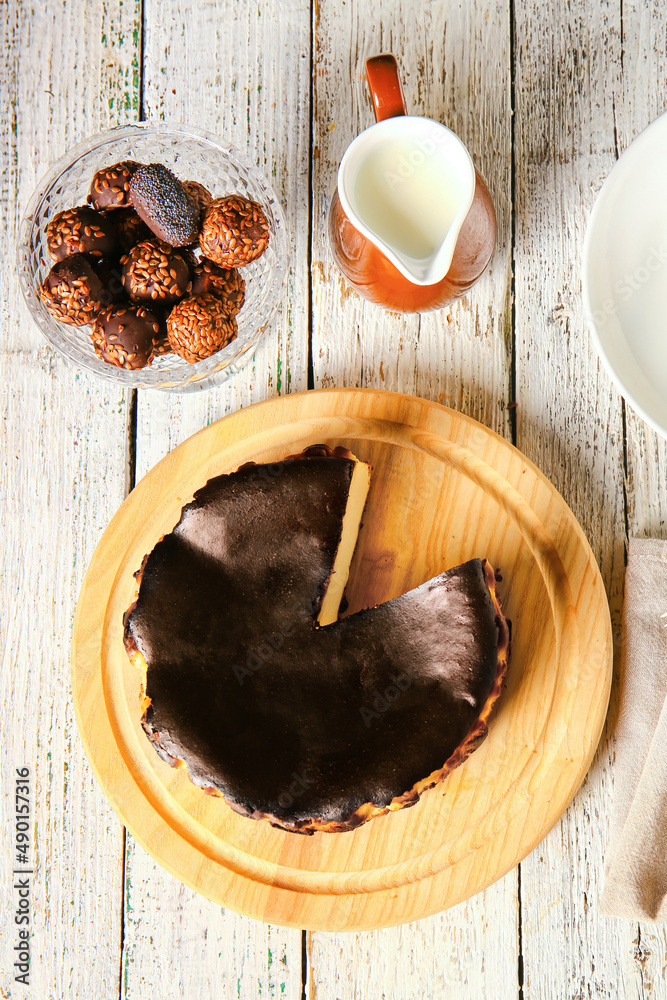 Tasty Basque burnt cheesecake on white wooden background