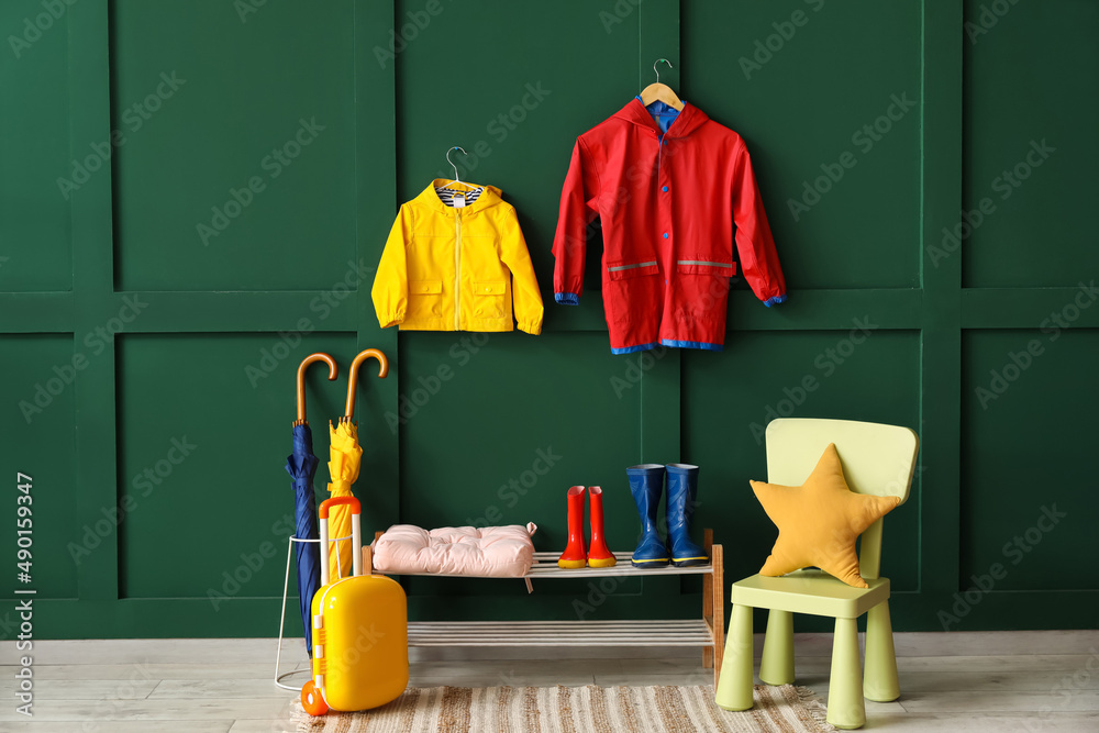 Interior of hallway with childs raincoats, gumboots and umbrellas