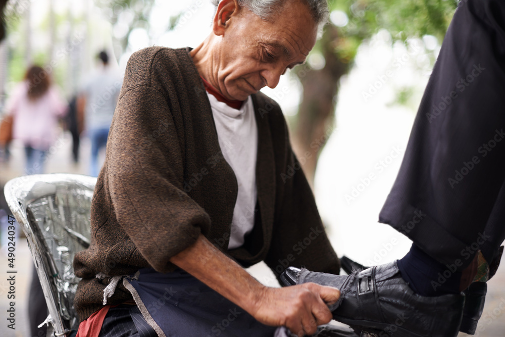 Keeping the businessmens shoes shiney. Cropped shot of a shoe shiner shining a businessmans shoes.