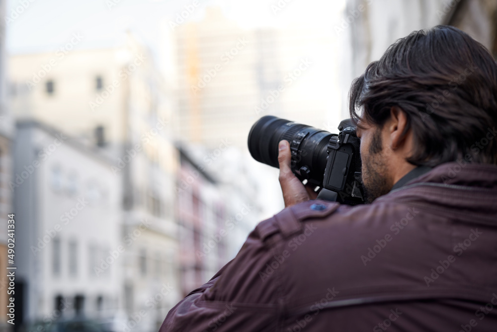 Capturing the beauty that surrounds him. A young man taking a picture with his camera.