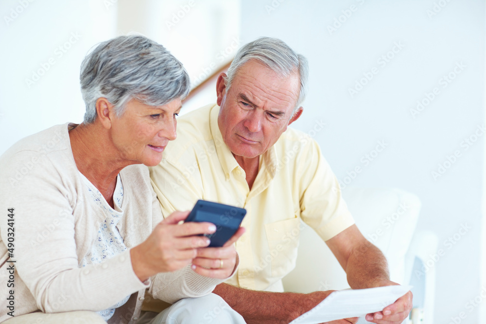 Couple calculating domestic budget. Mature Caucasian couple calculating domestic budget while sittin