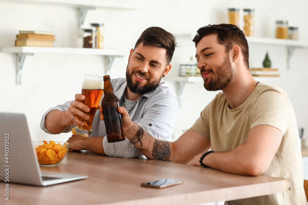 男性朋友在厨房的餐桌上喝啤酒