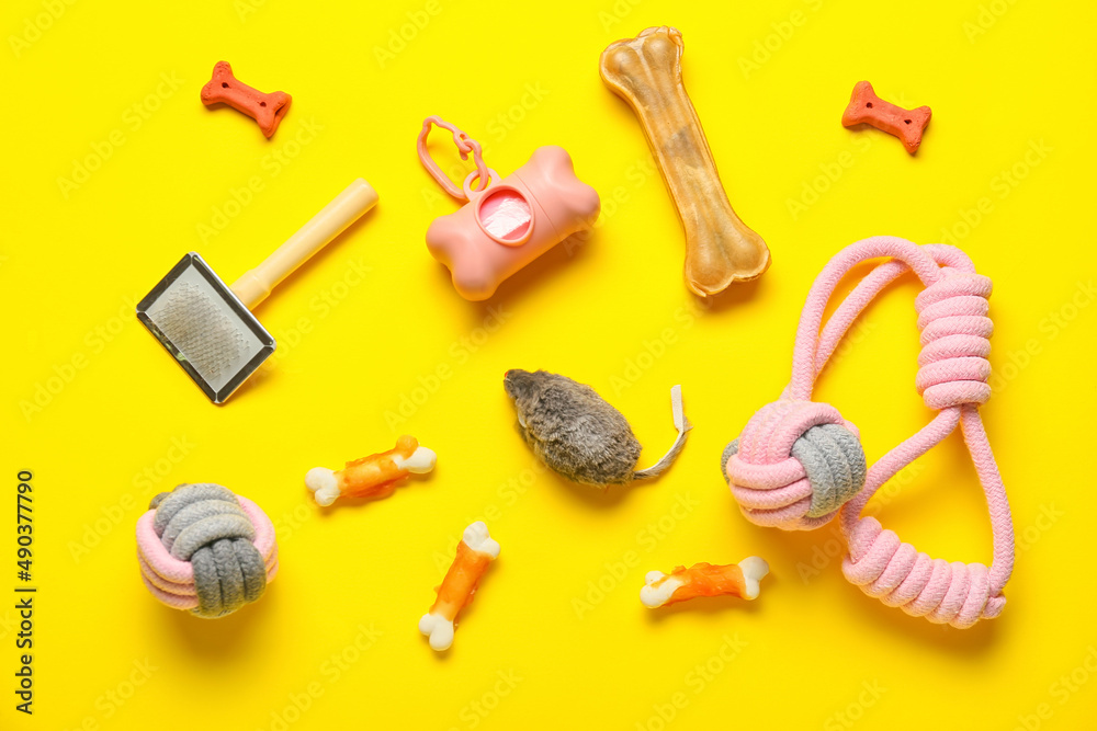 Set of pet care accessories and snacks on yellow background