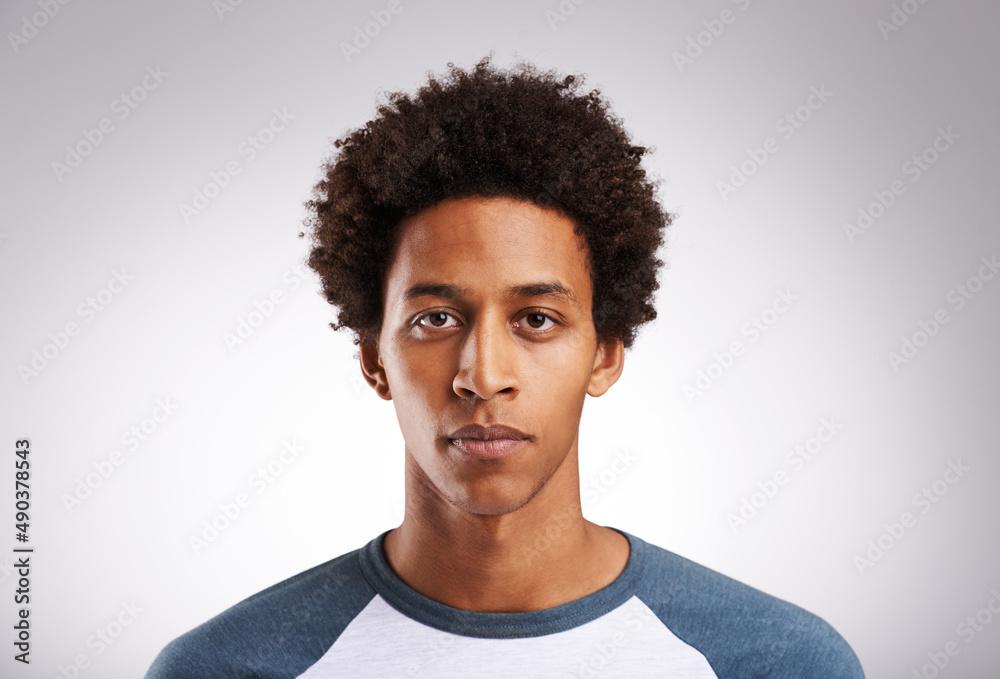 Im not here to be average.... Studio shot of a young man posing against a gray background.