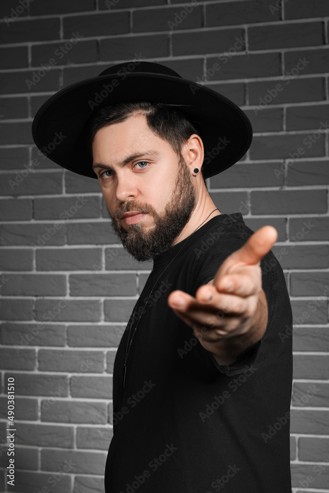 Stylish bearded man on dark brick background