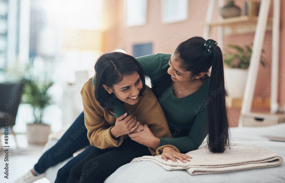 We always tease each other, just like when we were little. Shot of two happy young women sitting tog