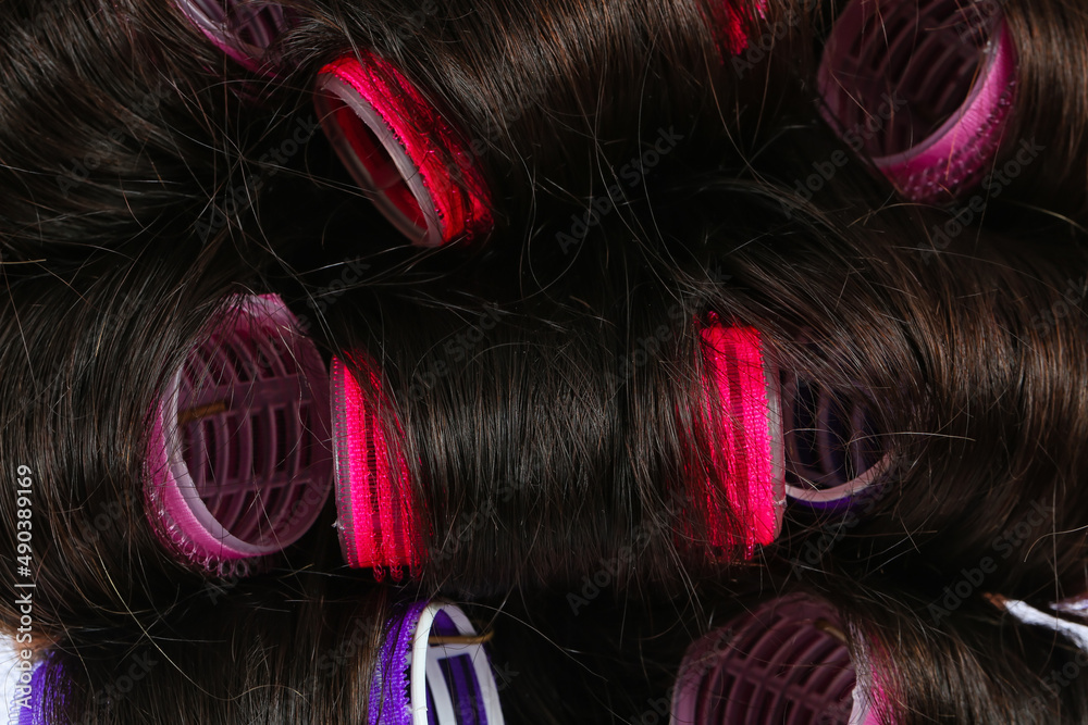 Curlers on brunettes hair, closeup view