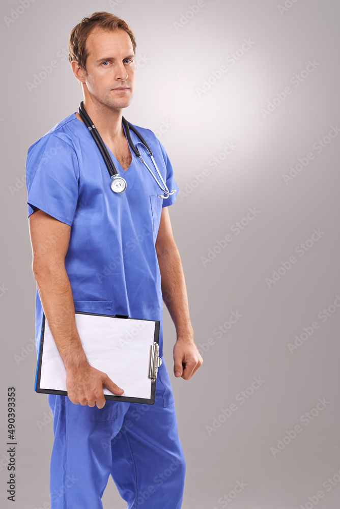 Hes serious about surgery. Studio portrait of a handsome male surgeon holding a clipboard.