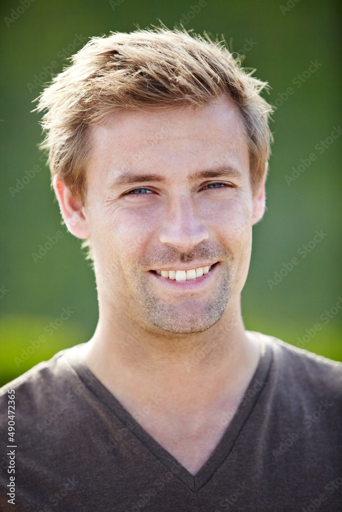 Casual charm. A handsome young man smiling broadly at the camera.