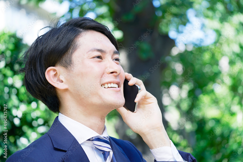 ビジネスマン　電話する　屋外