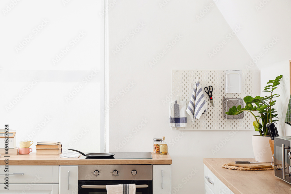 Stylish counters and pegboard in kitchen interior