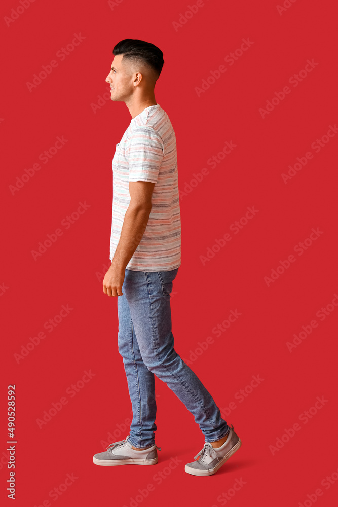 Handsome young man in stylish t-shirt on color background