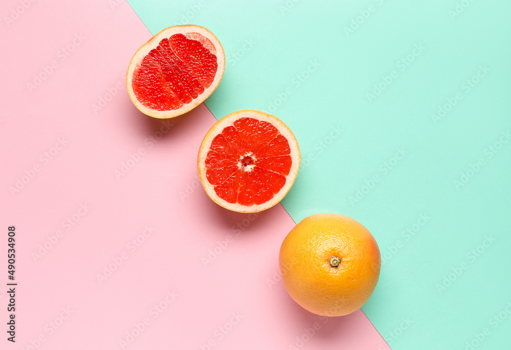 Tasty cut grapefruit on color background