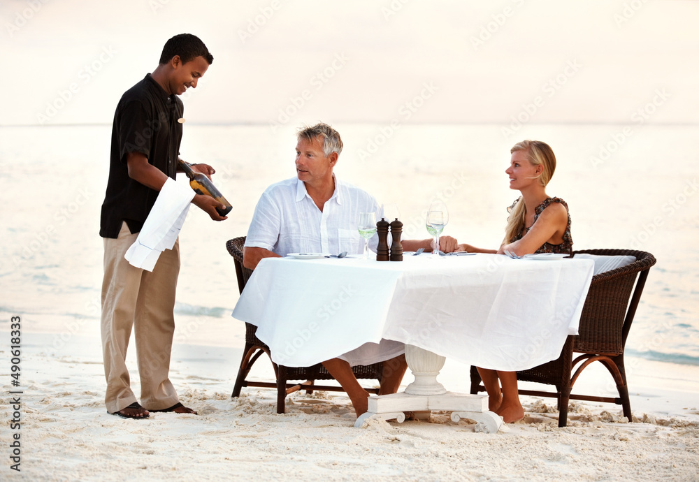 Mature couple having dinner at the beach. Shot of a mature couple enjoying a romantic dinner on the 