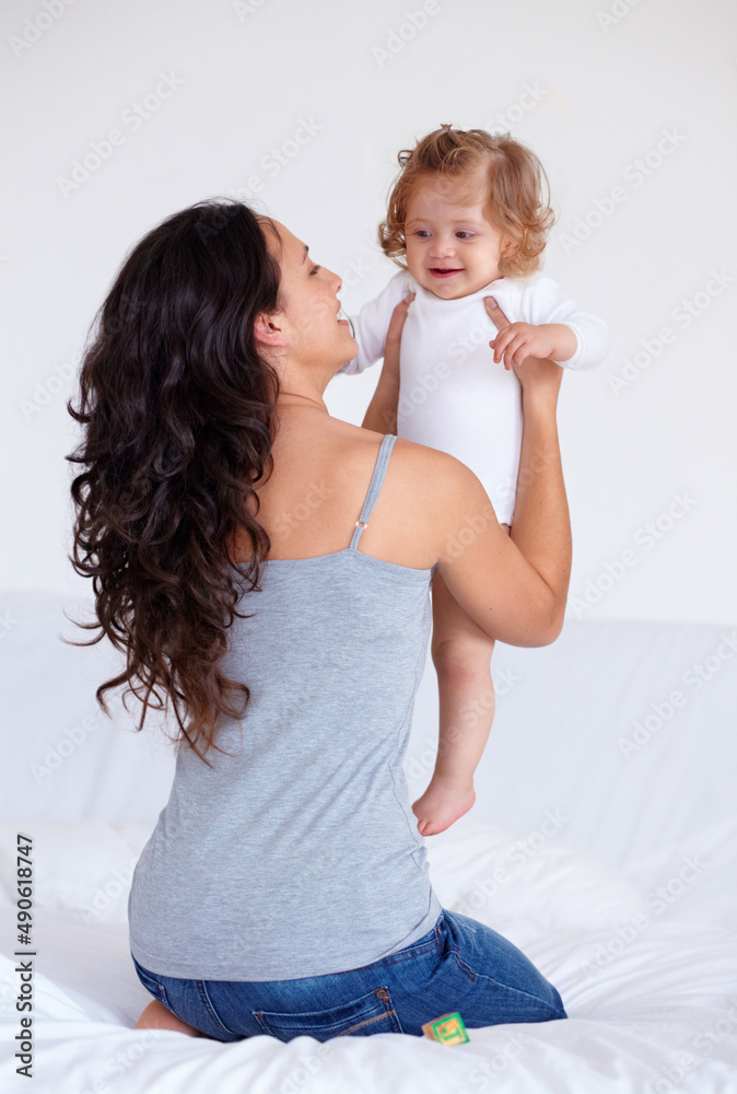 My gorgeous little angel. Rearview shot of a mother holding up her baby daughter.