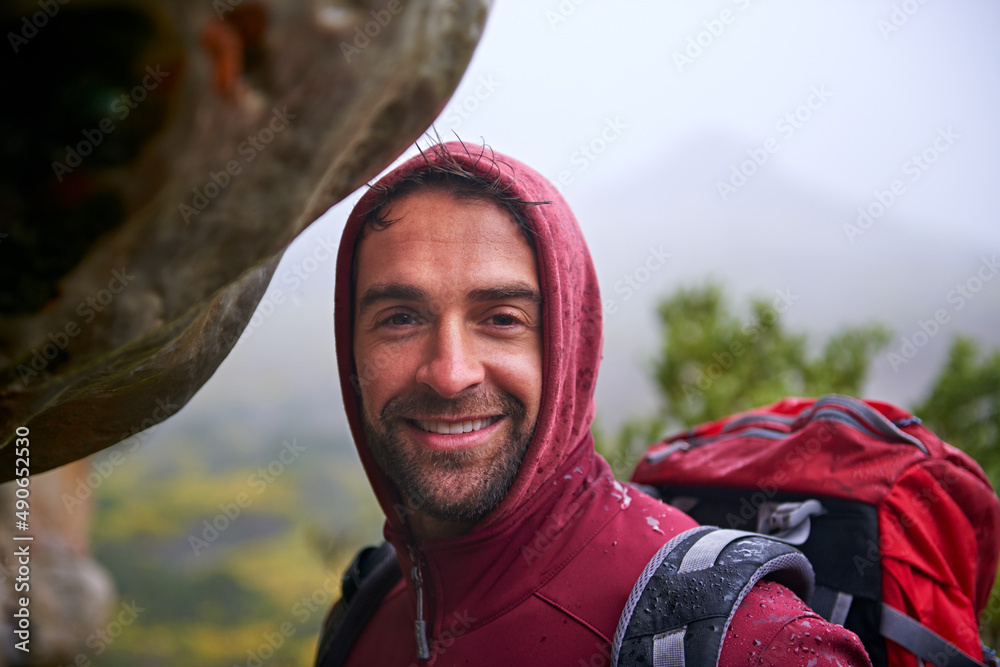 Looks like weve gotta go through. Shot of a young man enjoying a hike through the mountains.