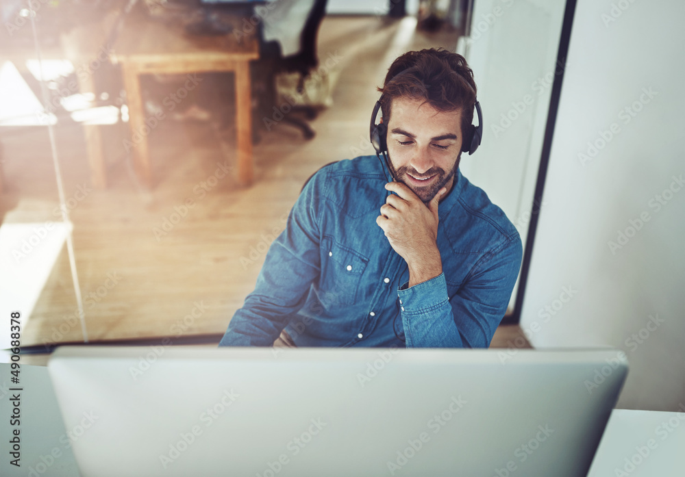 Hes always happy to be of assistance. High angle shot of a handsome young businessman wearing a head