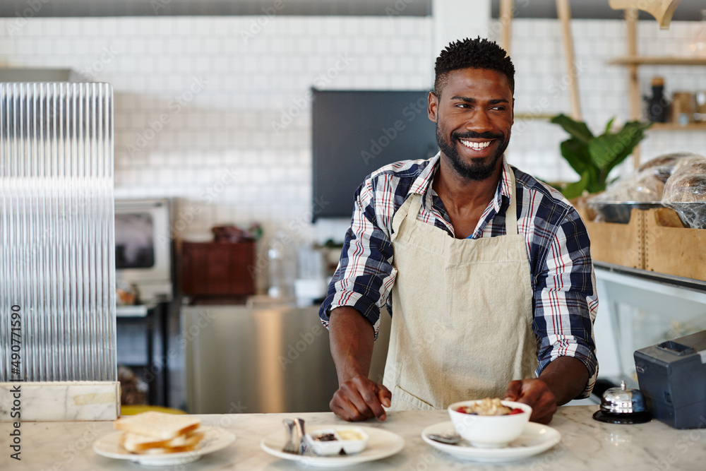 Breakfast - the most important meal of the day. Cropped shot of a handsome young man working in a ca