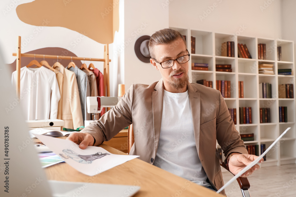 Young male clothes stylist working in studio