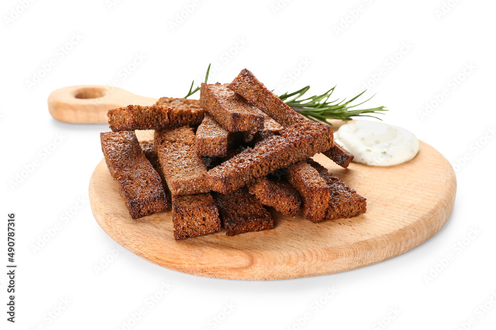 Wooden board with tasty croutons and sauce on white background