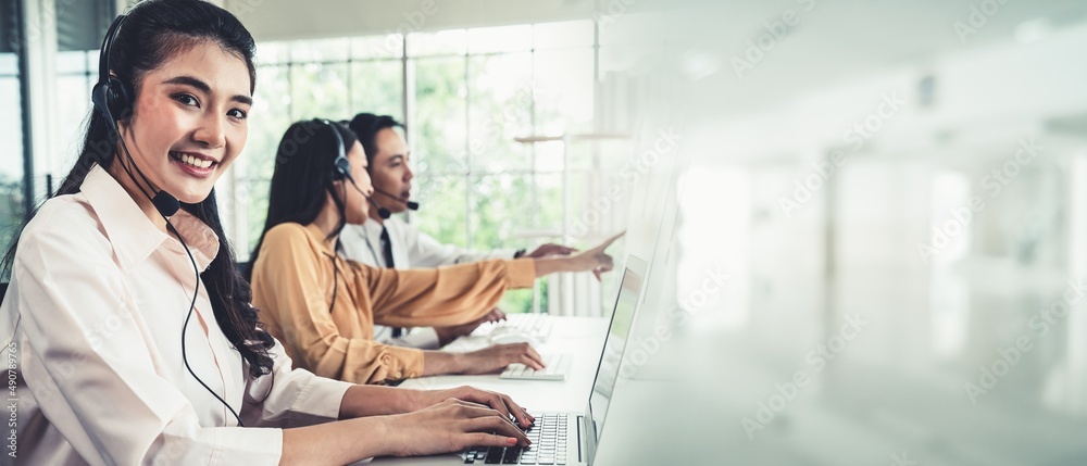 Business team wearing headset working actively in office . Call center, telemarketing, customer supp