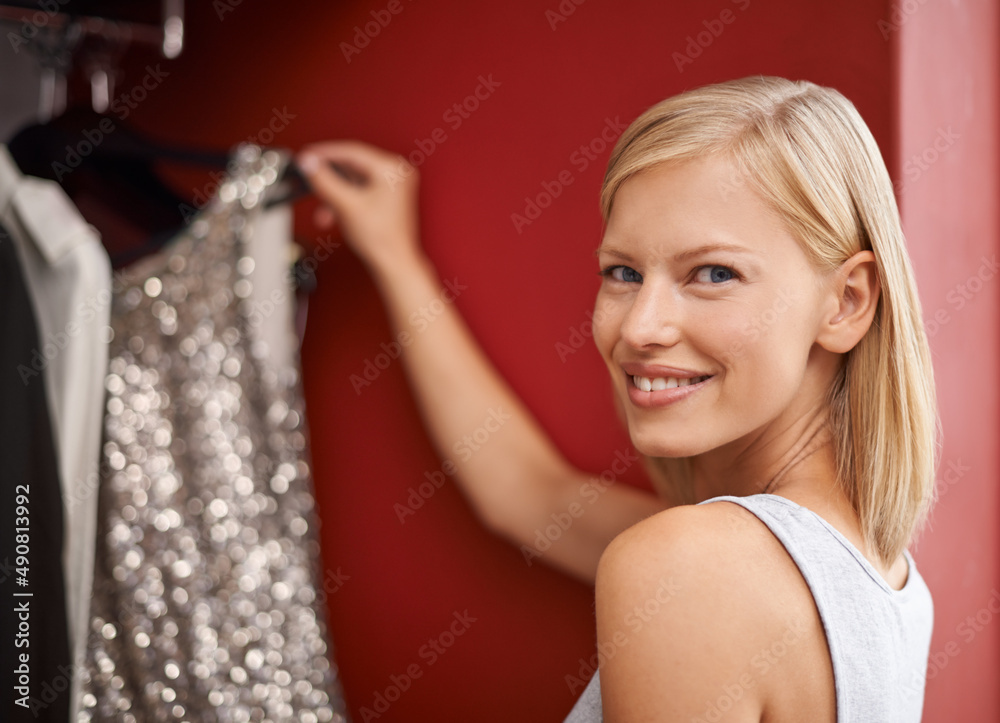 The perfect dress. Portrait of an attractive young woman picking out a dress from her wardrobe.