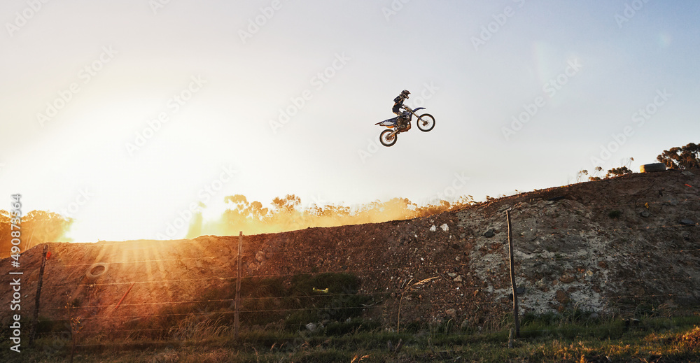 Theres not a competitor in sight. Shot of a motocross rider going over a jump during a race.