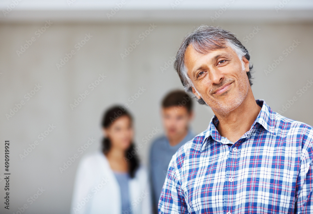 Mature architect with couple in background. Portrait of mature architect smiling with couple in back