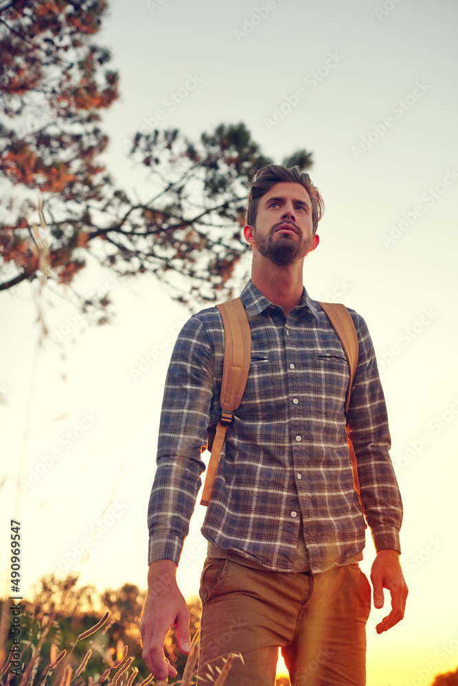 The perfect day for a hike. Shot of a handsome young man enjoying a hike.