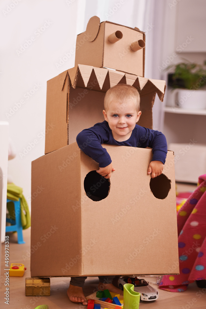 Im a robot and Im coming to get you. A young boy playing with a cardboard box cut into the shape of 