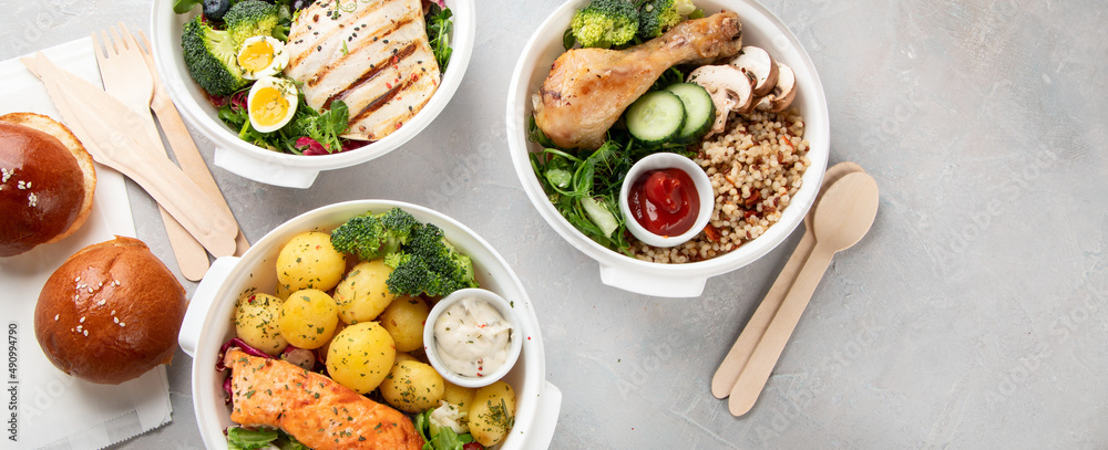 Healthy meal prep in lunch boxes on light background.