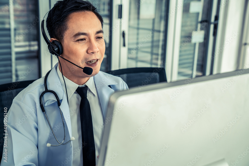 Doctor wearing headset talking actively on video call in a clinic or hospital . Concept of telehealt