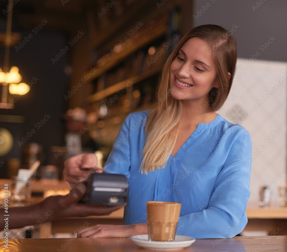 Payment has never been easier. Cropped shot of an attractive young woman making payment in a coffee 