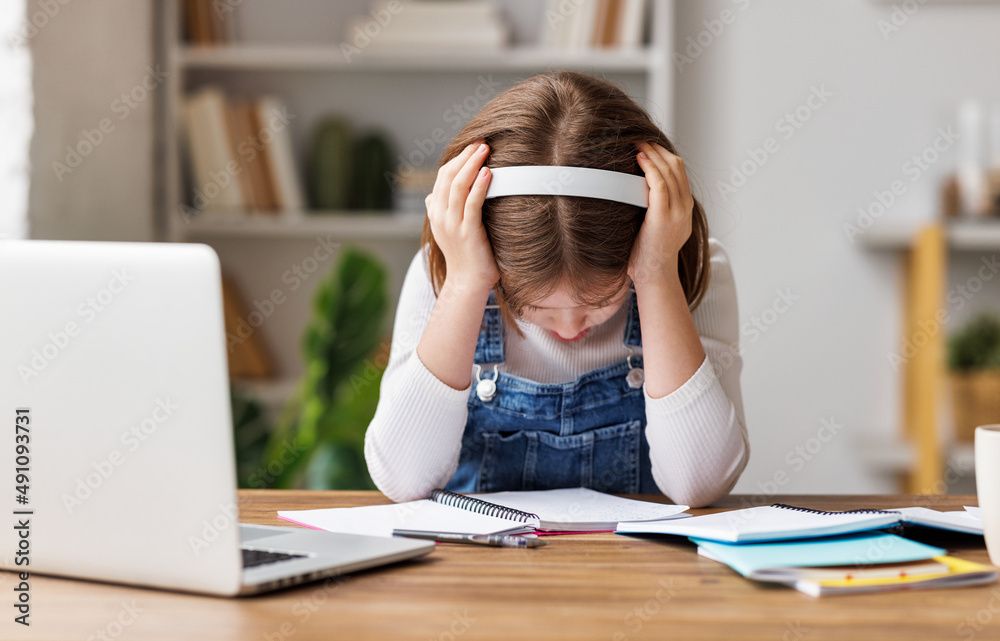 Confused child doing homework at home