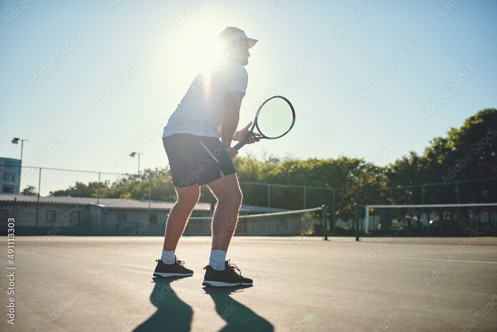 Be fair and play hard. Shot of a sporty young man playing tennis on a tennis court.