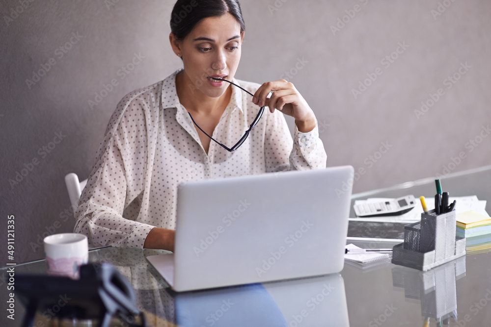 Solving the problem. Shot of a beautiful young business woman thinking at her desk.