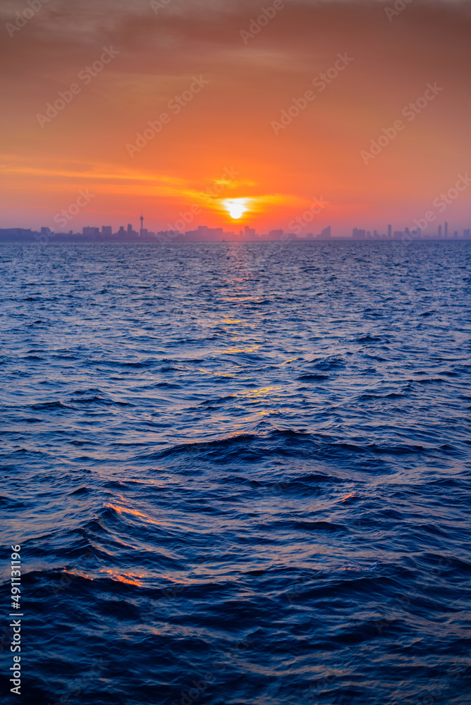 日出时以城市天际线为背景的碧海美景