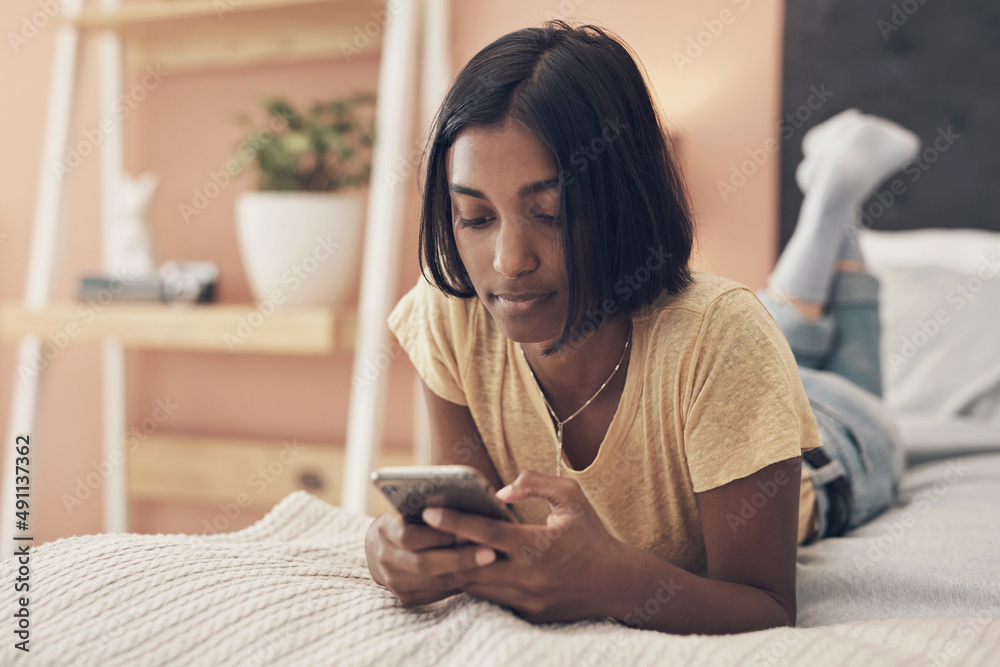 What would quarantine be without your social connection. Shot of a young woman using a smartphone wh