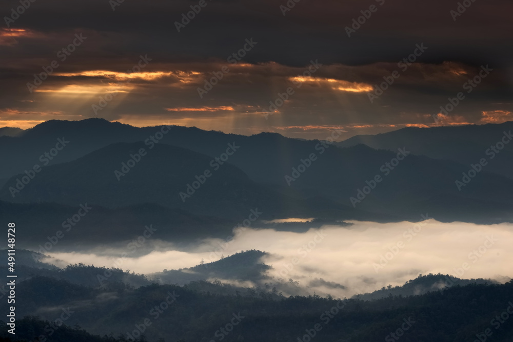 Beautiful sunlight ray over a mountain range and sea of fog in a valley