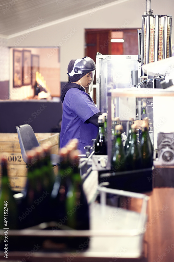 Working at the bottling plant. Shot of a worker in a wine bottling plant.