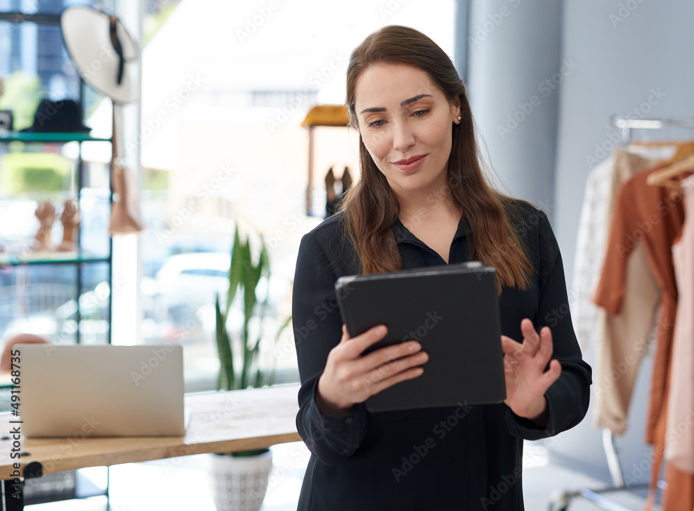 Her small business is big online too. Shot of a young business owner using a digital tablet in her c