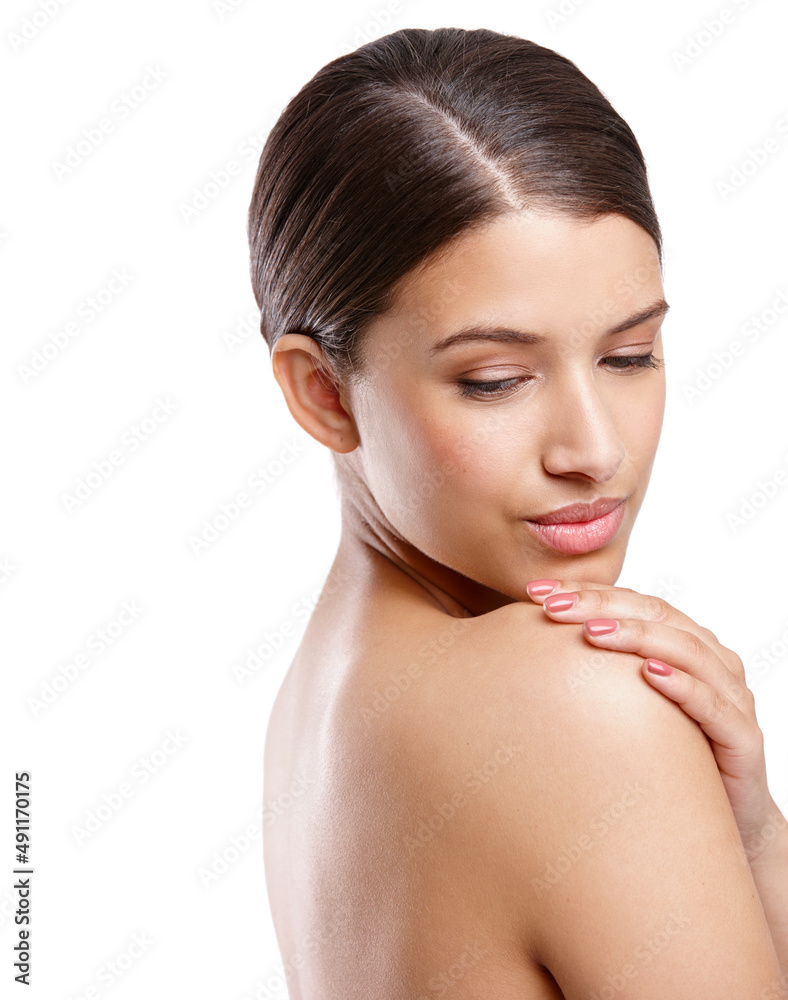 Shes got silky smooth skin. Studio shot of a beautiful young woman looking over her shoulder against