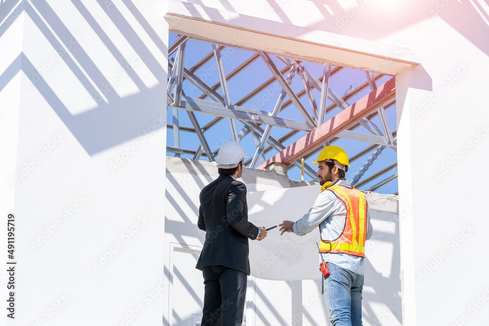 Structural engineer and foreman worker with blueprint discuss plan working for the new house constru