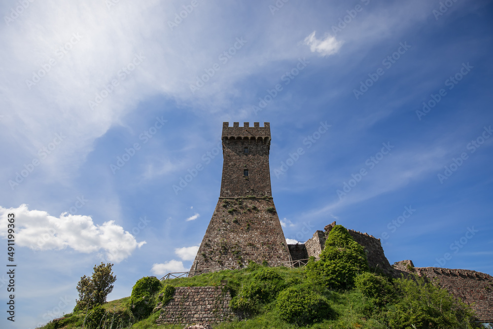 Brick tower Rocca of Radocofani with the cloudy sky background on a summer day, Tuscany, Italy (Val 