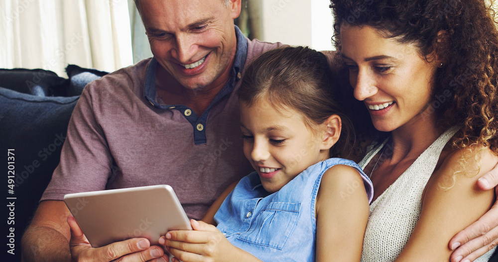 The modern family is more connected than ever. Shot of a cute little girl using a digital tablet wit