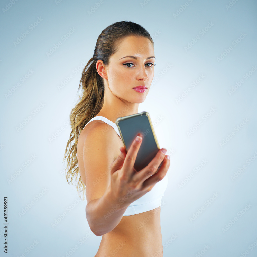 Do it for the after selfie. Studio shot of a beautiful and healthy young woman against a blue backgr